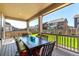 Covered outdoor patio featuring a dining table with chairs, set against the backdrop of a well-maintained lawn and fenced yard at 24326 E Ohio Dr, Aurora, CO 80018