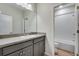 Bathroom featuring gray vanity and white tiled tub with shower at 9982 Wheeling St, Commerce City, CO 80022