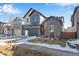 Two-story home featuring a two-car garage, gray siding and a snow-covered lawn at 9982 Wheeling St, Commerce City, CO 80022