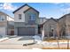 Two-story home featuring a two-car garage, gray siding and a snow-covered lawn at 9982 Wheeling St, Commerce City, CO 80022