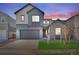 Two-story home featuring a two-car garage, gray siding and a well-maintained lawn at 9982 Wheeling St, Commerce City, CO 80022