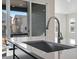 Bright kitchen island with quartz countertops, stainless steel sink, and a view of the backyard at 9982 Wheeling St, Commerce City, CO 80022