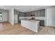 Open kitchen with stainless appliances, gray cabinets, island, and easy access to other rooms at 9982 Wheeling St, Commerce City, CO 80022
