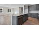 Modern kitchen island with stainless steel dishwasher and sink with gray cabinets and wood floors at 9982 Wheeling St, Commerce City, CO 80022