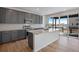 Modern kitchen featuring an island, stainless steel appliances, and a stylish backsplash, with hardwood floors at 9982 Wheeling St, Commerce City, CO 80022