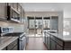 Gourmet kitchen features stainless steel appliances, quartz countertops, and access to the outdoor patio at 9982 Wheeling St, Commerce City, CO 80022