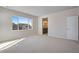 Spacious main bedroom with a view of the neighborhood and an entrance to the main bathroom at 9982 Wheeling St, Commerce City, CO 80022