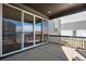 Covered patio with sliding glass doors and black railing, overlooking an undeveloped community at 9982 Wheeling St, Commerce City, CO 80022