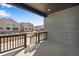 Covered patio with black railing, overlooking homes in an undeveloped community at 9982 Wheeling St, Commerce City, CO 80022