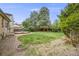 Private backyard featuring a wooden deck, mature trees, and gravel landscape at 1549 S Evanston St, Aurora, CO 80012