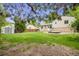Wide backyard with green grass, wooden shed, deck, and tree coverage at 1549 S Evanston St, Aurora, CO 80012