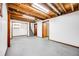 Spacious basement featuring exposed ceiling, painted floors, and wood-trimmed doorways at 1549 S Evanston St, Aurora, CO 80012