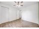 Bright bedroom with wood-look floors, a ceiling fan, and ample closet space at 1549 S Evanston St, Aurora, CO 80012