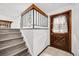 A home entryway featuring stairs, a dark wooden handrail, and a tiled floor with a wooden front door at 1549 S Evanston St, Aurora, CO 80012