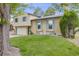 Charming home with a two-car garage, a basketball hoop, and blue shutters and a green lawn in front at 1549 S Evanston St, Aurora, CO 80012