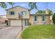 Charming home with a two-car garage, a basketball hoop, and blue shutters in front of a green lawn at 1549 S Evanston St, Aurora, CO 80012
