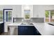 Bright kitchen boasts stainless steel appliances, contrasting cabinets, and a sink beneath a sunlit window at 1549 S Evanston St, Aurora, CO 80012
