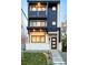 Modern three-story home featuring black metal accents, balconies, and a charming covered front porch at 3435 W 17Th Ave, Denver, CO 80204