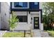 Striking front entrance of a modern home, featuring a black door, light brick, and neat landscaping at 3435 W 17Th Ave, Denver, CO 80204