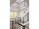Open staircase with modern black railings and light wood treads, enhanced by striking pendant lighting, filling the space at 3435 W 17Th Ave, Denver, CO 80204