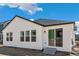 Exterior view of the new house, showcasing white siding, dark trim, and glass doors accessing the backyard at 13575 E 110Th Ln, Commerce City, CO 80022