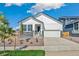 Charming white home featuring a two-car garage and nicely landscaped front yard at 13575 E 110Th Ln, Commerce City, CO 80022