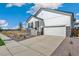 New home with a two-car garage, white siding, stone accents, and xeriscaping at 13575 E 110Th Ln, Commerce City, CO 80022