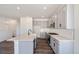 Open kitchen with quartz counters, stainless appliances, an island sink, gray cabinets and an adjacent dining area at 13575 E 110Th Ln, Commerce City, CO 80022