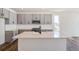 Bright kitchen boasts gray cabinets, stainless steel appliances, quartz countertops, island sink and white subway tile backsplash at 13575 E 110Th Ln, Commerce City, CO 80022