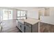 Kitchen island featuring gray cabinets, a farmhouse sink, quartz countertops, and open access to the living area at 13575 E 110Th Ln, Commerce City, CO 80022