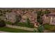 Aerial view of the home showcasing the backyard patio, lush lawn, mature trees, and neighborhood at 11691 Riverdale Dr, Parker, CO 80138