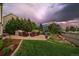 Landscaped backyard patio featuring an outdoor kitchen, seating area, and lush greenery, perfect for entertaining at 11691 Riverdale Dr, Parker, CO 80138