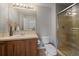 The bathroom features a stand-up shower, wooden cabinets, and a large mirror at 11691 Riverdale Dr, Parker, CO 80138