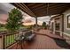 Beautiful sunset view from the home's covered wood deck with comfortable seating and stylish railings at 11691 Riverdale Dr, Parker, CO 80138