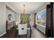 Bright dining room featuring a modern chandelier, wood floors, and a large window with neighborhood views at 11691 Riverdale Dr, Parker, CO 80138
