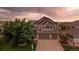 Stunning two-story home featuring a three-car garage, mature tree, and manicured lawn on a large lot at 11691 Riverdale Dr, Parker, CO 80138