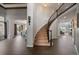 Elegant foyer with curved staircase, hardwood floors, and open view to the dining and living areas at 11691 Riverdale Dr, Parker, CO 80138