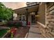 Inviting front porch with stone accents, black columns, and beautifully landscaped flower beds at 11691 Riverdale Dr, Parker, CO 80138
