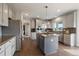 Open kitchen features gray cabinetry, granite countertops, stainless steel appliances, and an island cooktop at 11691 Riverdale Dr, Parker, CO 80138