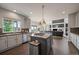 Open concept kitchen featuring gray cabinetry, granite countertops, and stainless steel appliances with an island cooktop at 11691 Riverdale Dr, Parker, CO 80138