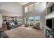 Bright living room featuring tall ceilings, large windows, and a fireplace, open to the kitchen and dining area at 11691 Riverdale Dr, Parker, CO 80138