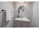 Stylish powder room features a gray vanity, a decorative mirror, and modern fixtures at 11691 Riverdale Dr, Parker, CO 80138