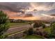 Scenic neighborhood view with lush landscaping, wide streets, and beautiful sunset at 11691 Riverdale Dr, Parker, CO 80138