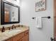 Well-lit bathroom with a granite vanity, mirror with black trim, and framed inspirational quote at 2308 Hearth Dr # 36, Evergreen, CO 80439