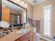 Traditional bathroom featuring a marble-look vanity, glass-enclosed shower, and a stained glass window at 2308 Hearth Dr # 36, Evergreen, CO 80439