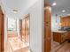 Bright hallway featuring wooden floors, coat closet, and leads into the kitchen with natural wood cabinets at 2308 Hearth Dr # 36, Evergreen, CO 80439