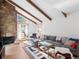 Bright living room featuring a stone fireplace, wood beams, and large windows offering plenty of natural light at 2308 Hearth Dr # 36, Evergreen, CO 80439