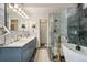 Spa-like bathroom featuring double sinks, a glass enclosed shower, and a soaking tub at 9117 Nambe Trl, Lone Tree, CO 80124