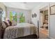 Comfortable bedroom with natural light, a patterned comforter, and an adjoining bathroom at 9117 Nambe Trl, Lone Tree, CO 80124