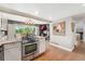 Modern kitchen with stainless steel range, granite countertops, island, and open layout to dining area and fireplace at 9117 Nambe Trl, Lone Tree, CO 80124